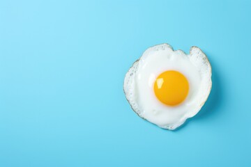 One fried egg isolated on blue background, top view