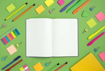 Open notebook with space for your text with colorful school and office supplies