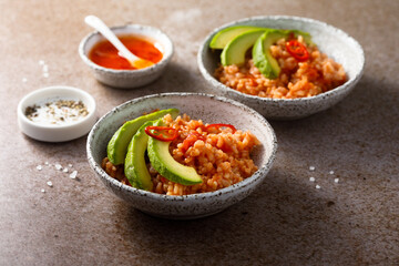 Spicy rice with avocado and chili sauce