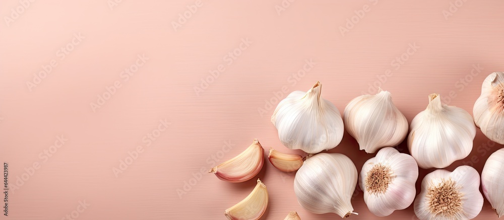 Poster Scattered garlic cloves on a black table Key in various global dishes A nutritious item isolated pastel background Copy space