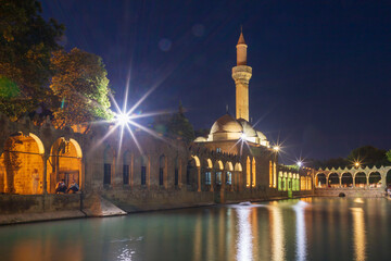 Sanliurfa, Turkey - June 19, 2023 : Balıklıg&ouml;l (Balık Lake) and Rizvaniye Mosque Landscape in beautiful sunset scenery in Şanlıurfa, Turkey.
