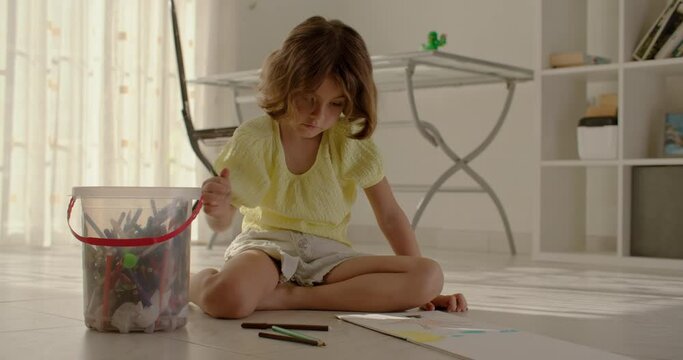 Little Hands, Grand Visions: Preschool Girl's Artistic Flourish Fills the Living Room with Imagination. High quality 4k footage