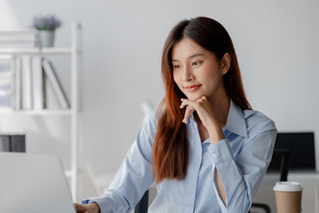 Asian woman sitting in startup company office, marketing analyzing and planning marketing for company growth, sales management. Businessman concept, marketing planning.