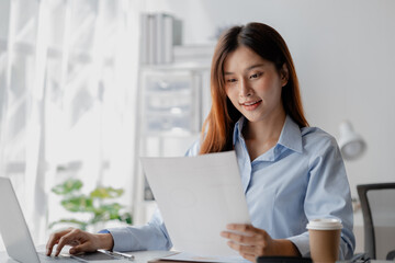 Asian woman sitting in startup company office, marketing analyzing and planning marketing for company growth, sales management. Businessman concept, marketing planning.