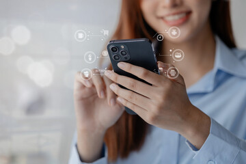 Asian woman holds a smartphone. She is shopping online on the smartphone and browsing social media to review products before ordering. Using a credit card to pay for goods and services on the internet