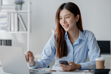 Asian woman holding smartphone, businesswoman using smartphone for social media and messaging with friends, using smartphone to send work email. Concepts of communication via the internet.