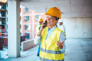 Female engineer in the hard hat uses mobile phone, Industrial worker using mobile smartphone. Shot of a young woman using a smartphone while working at a construction site
