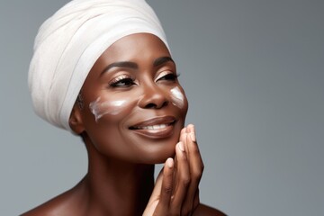 Portrait of a fifty year old african woman with moisturizer applied to her face.