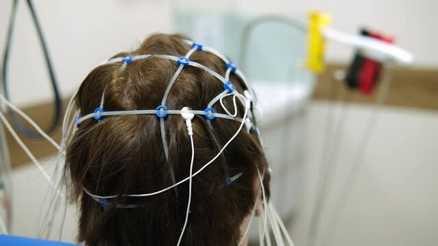 The doctor prepares the patient for an encephalogram of the brain.