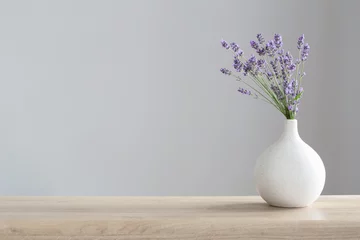 Fototapeten lavender flowers in ceramic vase on gray background © Maya Kruchancova