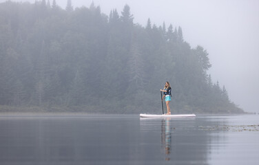 Woman on a paddle board at dawn