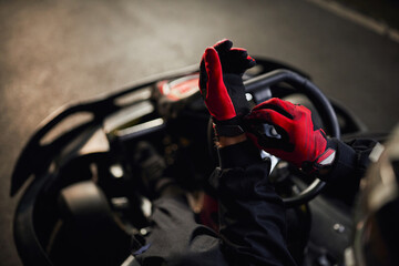 top view of go kart driver  wearing red racing gloves, preparing for competition concept