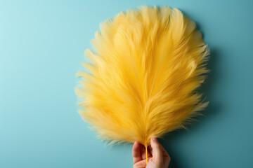 Easter background with soft yellow small feathers on blue background