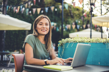 Stylish businesswoman working on lunch break at urban coffee shop.