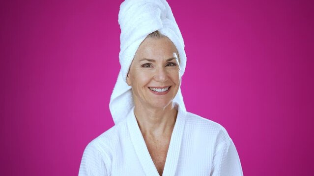 Portrait of happy smiling beautiful middle aged mature woman wearing bathrobe at spa salon. Body care procedures anti age delicate dry skin care products concept isolated on white background.