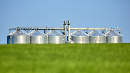 Agricultural Silos - Building Exterior, Storage and drying of grains, wheat, corn, soy, sunflower against the blue sky with wheat fields. © Seneca CDR