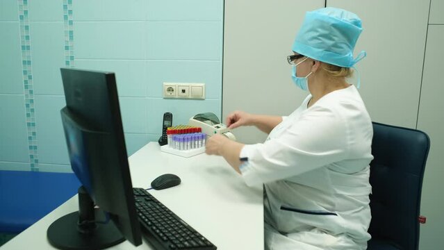 A nurse puts a barcode on a blood test tube.