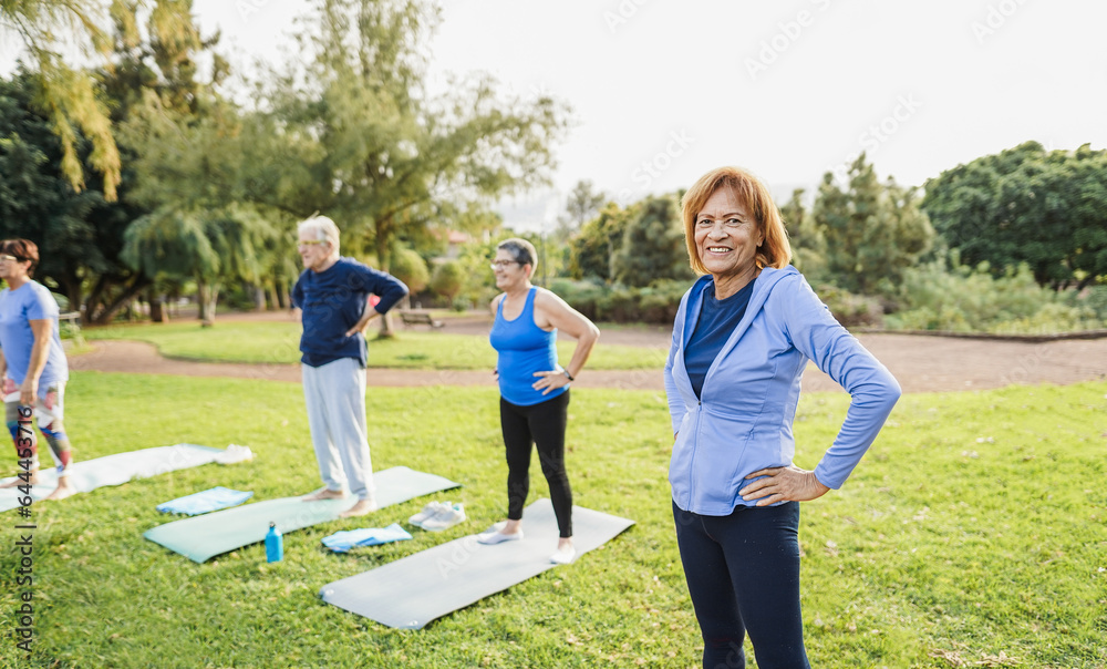 Wall mural multiracial senior people doing workout exercises outdoor with city park in background - healthy lif