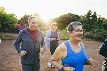 Fit senior people running at city park - Group of elderly friends doing sport workout together...