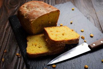 Homemade cornbread loaf and slices on kitchen table
