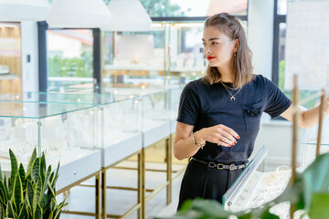 Elegant sucsessful business woman in black wear and red lips owner of jewelry store with modern...