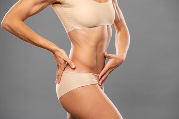 Fitness portrait of young muscular woman in sports underwear