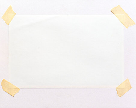 A blank frame attached on a paper page with adhesive tape.