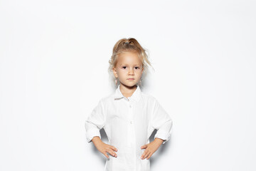 Studio portrait of serious child girl isolated on white background.