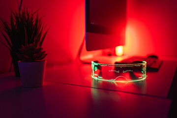 Desktop monitor with keyboard AR glasses and glowing red neon light on desk