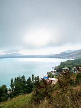 view of shore of Lake Sevan from Sevanavank Monastery on overcast summer day, Armenia