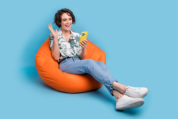 Full length photo of sweet excited woman dressed print shirt communicating modern gadget empty...