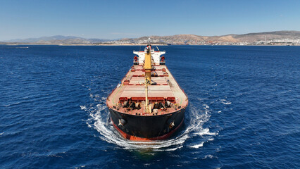 Aerial drone photo of bulk carrier ship carrying heavy merchandise and cruising deep blue open ocean sea