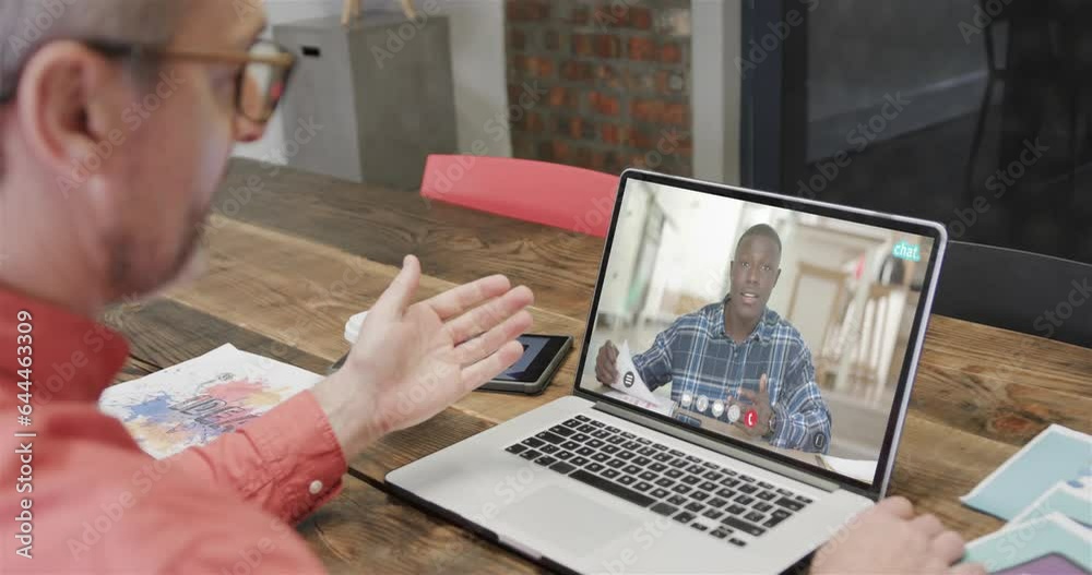 Wall mural Caucasian businessman on laptop video call with african american male colleague on screen