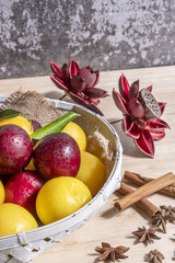 A basket full of ripe red and yellow plums