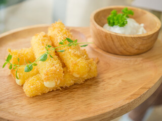 fried cheese stick on a wooden pate