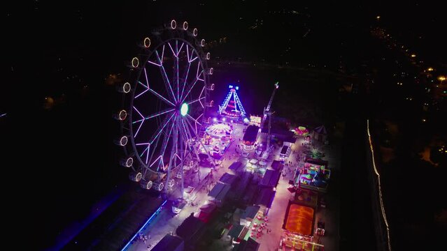 Aerial view of Vibrant amusement park at night with illuminated cityscape in Turia Park, Mestalla, Valencia, Spain