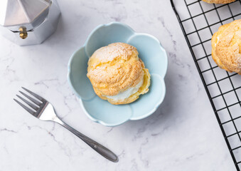 Choux cream, vanilla whipped cream stuffed cake in a blue bowl