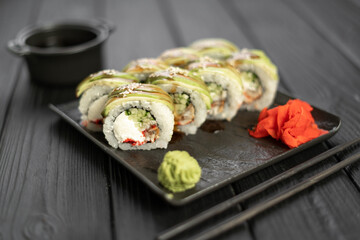 Traditional asian rice sushi healthy seafood. Japanese cuisine fresh rolls sushi green dragon on black slate