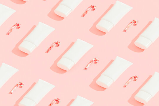 Pattern with cosmetics and candy canes on pink background. Christmas sale concept