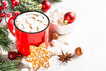 Obraz na płótnie Canvas Hot chocolate with marshmallow and gingerbread cookies and holiday decorations at white table.