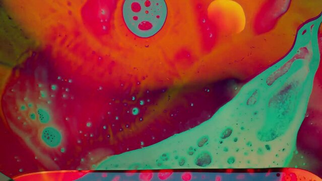 1970s psychedelic liquid projection with vibrant swirl of colours. Artistic dye pattern in ink and oil. Abstract artwork of cosmic visual reaction.