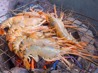 raw shrimp grilled on a stove with fire