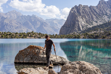 Man hiker exploring mountains lake in Tajikistan