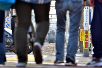 鎌倉腰越駅から降りた歩行者の間から見える江ノ電