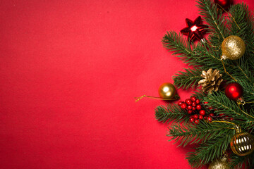 Christmas background with fir tree and decorations at red background. Top view with space for your text.