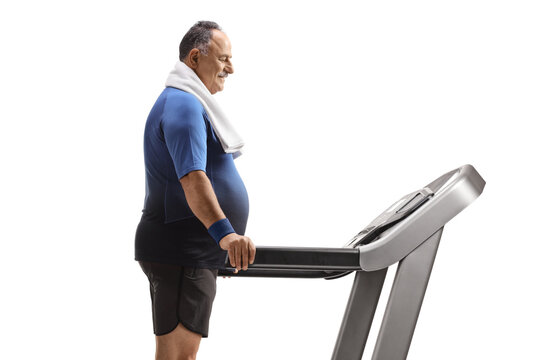 Profile shot of a mature man standing on a treadmill with a towel around his neck