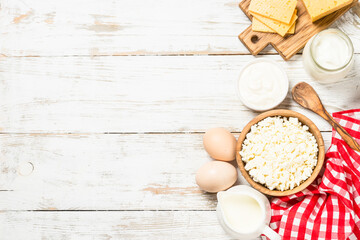 Dairy product at white wooden table. Curd, milk, yogurt, cheese and eggs. Organic farmer food. Top view with copy space.