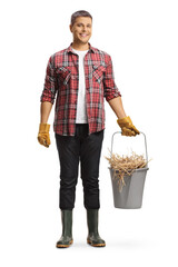 Full length portrait of a farmer holding a bucket with hay