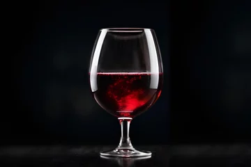Fotobehang Red wine in wine glass on black background. Commercial promotional photo © Logvin art