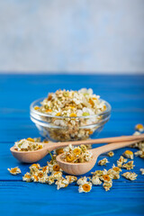 Dry chamomile flowers on a wooden table. Soothing chamomile tea. Herbal drink. flat layout. Space for text.Copy space.Medical prevention and immune concept. Folk alternative medicine.